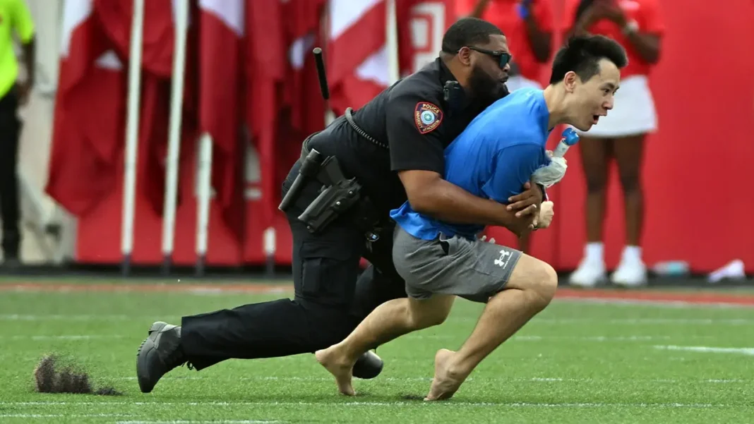 Fan runs onto field Police tackle intruder in Houston Cougars game